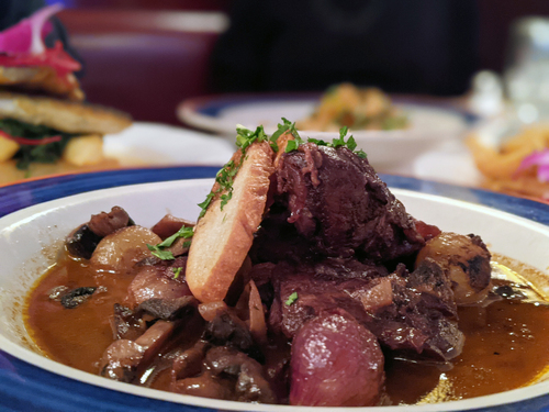 Braised beef with mushrooms, pearl onions and a toast slice in brown sauce